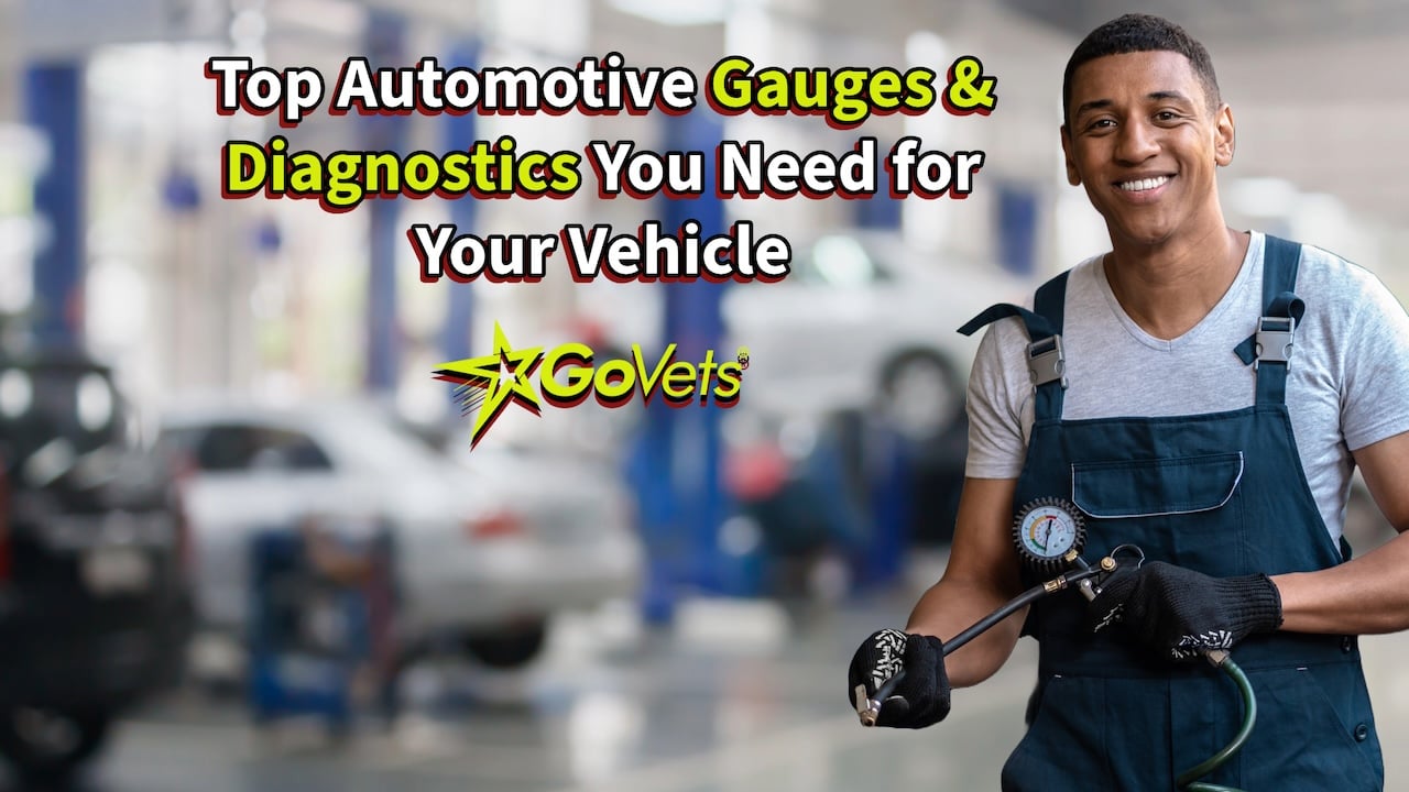 Mechanic in Auto repair shop with a Tire Gauge in his hand with several vehicles in the background