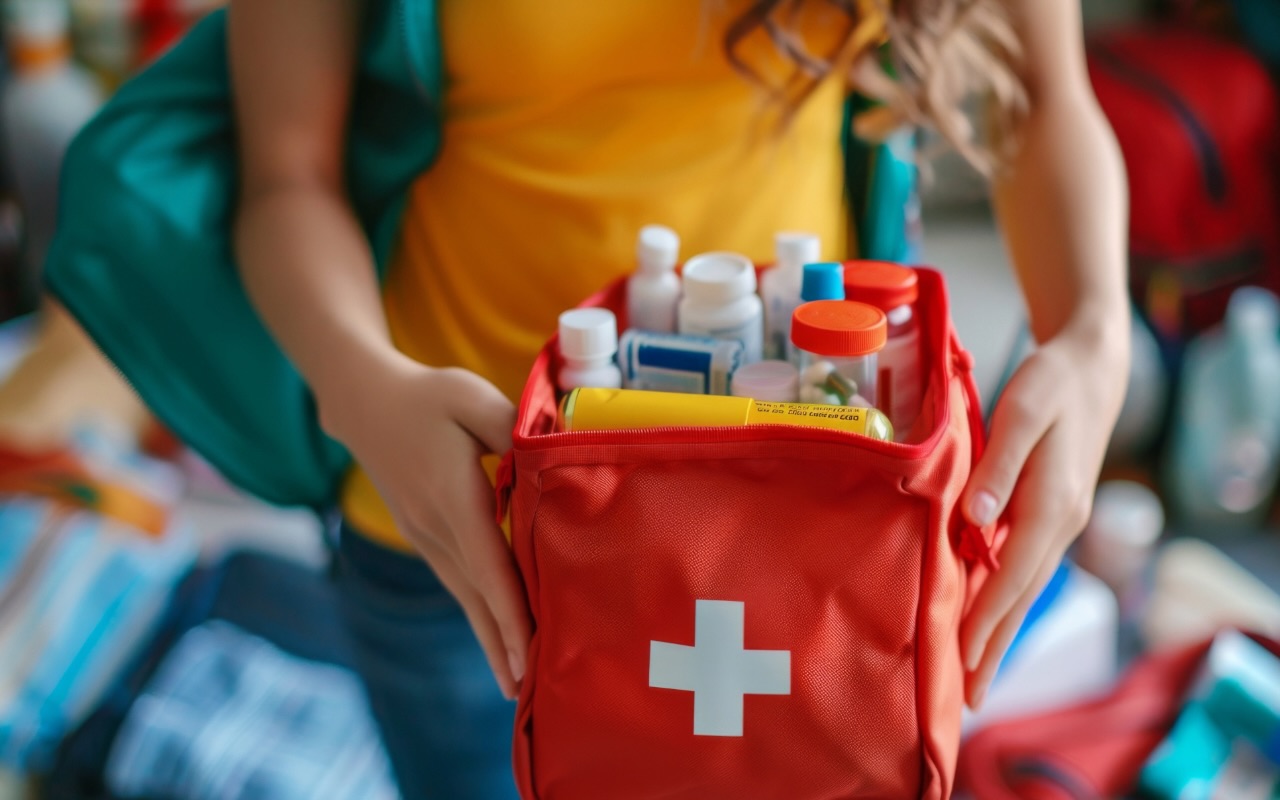 Emergency - first aid kit - person holding kit with supplies